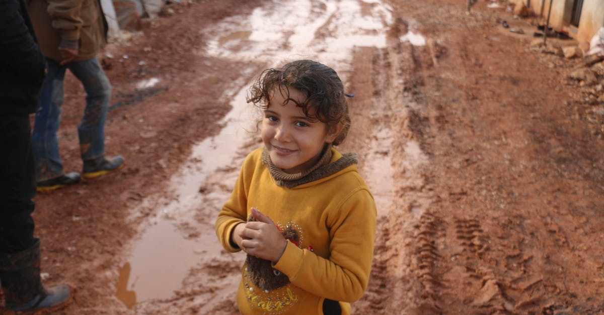 Do I need to physically crop my passport photo? - Smiling ethnic girl standing on dirty ground