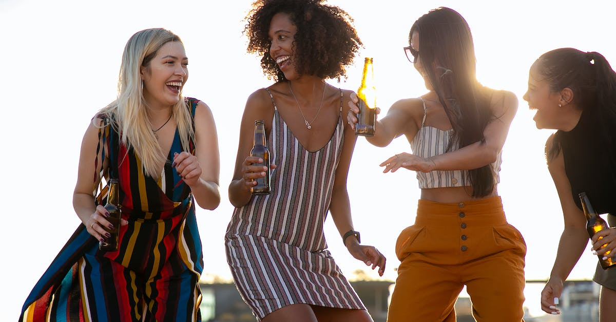 Do I really have to register with the police when staying with a friend in Croatia? - Group of cheerful young multiracial ladies laughing and dancing with beer bottles in hands during summer party on rooftop on sunny day