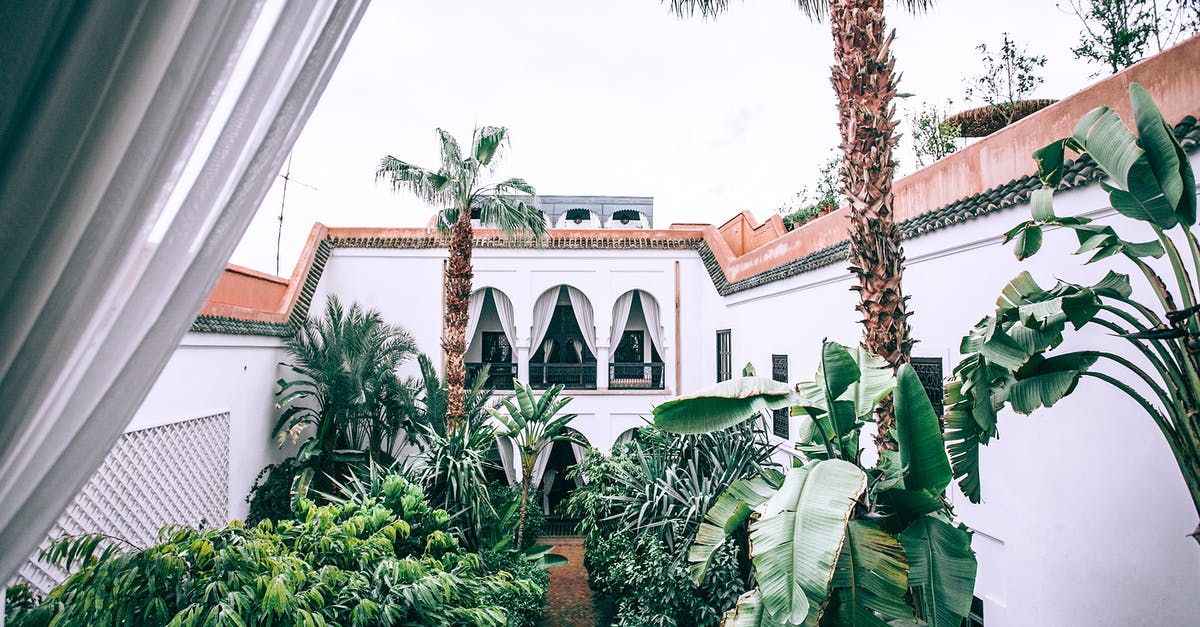 Do the new Canadian hotel quarantine requirements apply to non-residents? - White mansion patio with lush topical trees