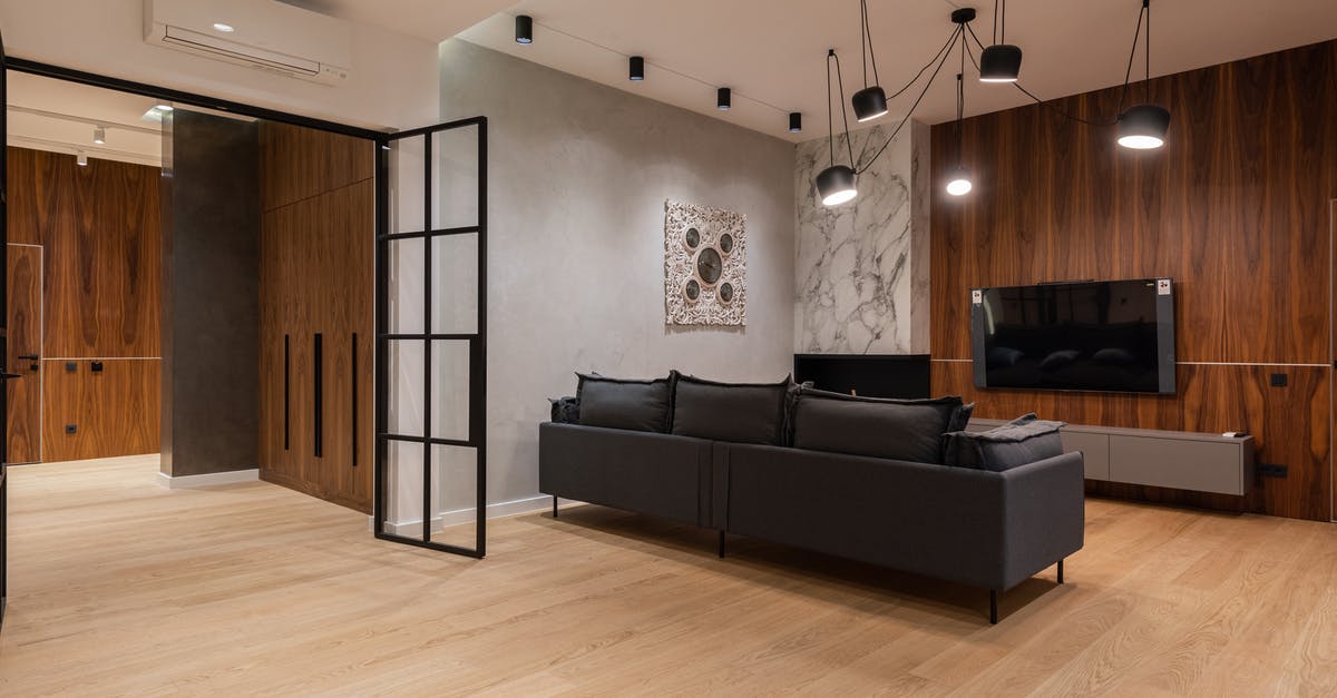 Do the new Canadian hotel quarantine requirements apply to non-residents? - Interior of spacious modern living room with comfortable sofa and TV set hanging on wooden wall under loft styled lamps