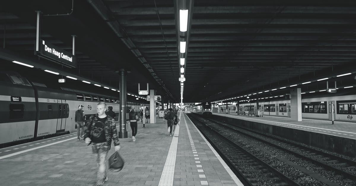 Do trains in Europe run on Christmas day? - Grayscale Photography of Man Carrying Bag Walking on Subway Station