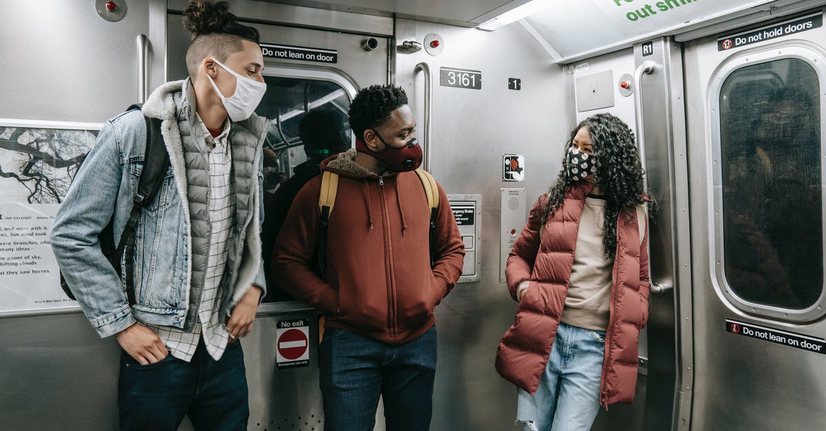 Documentation of a Covid booster shot for travel - Diverse passengers speaking while travelling on subway