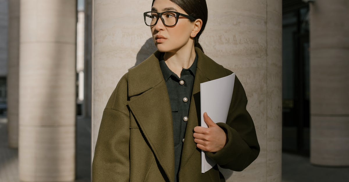 Documents required for B2 at airport - Woman in Brown Coat Holding White Paper