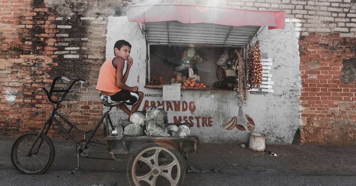 Does a 7 years old child need a separate bank statement? - Ethnic boy sitting on aged tricycle near poor street stall