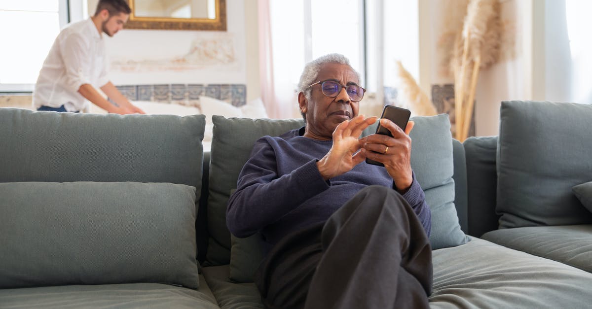 Does a seat cushion help for 12+ hour flights? - Man in Black Long Sleeve Shirt Sitting on Gray Couch