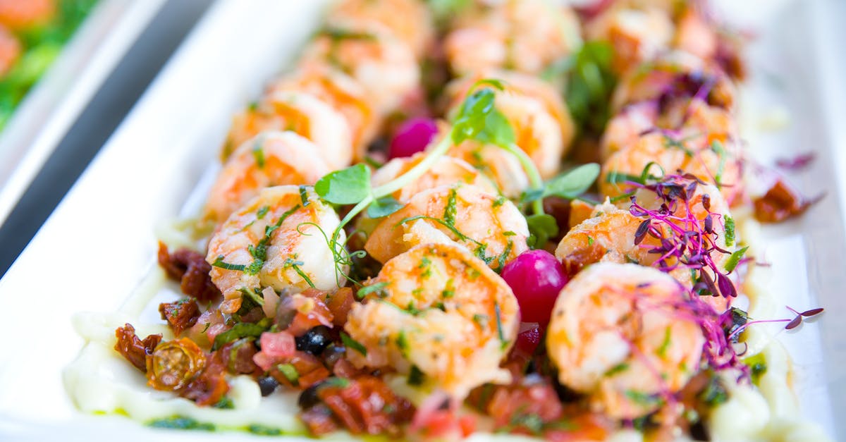 Does a third-party booking service know you've missed a flight? - Closeup of delicious shrimps with vegetables and microgreens on white plate on catering table