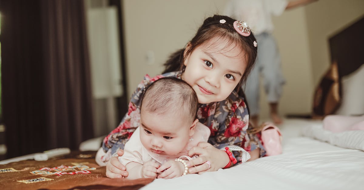 Does a US baby born in France received the mother's visitor visa benefits? - Happy Asian girl child embracing newborn baby lying on bed Does a US baby born in France received the mother's visitor visa benefits? - Happy Asian girl child embracing newborn baby lying on bed