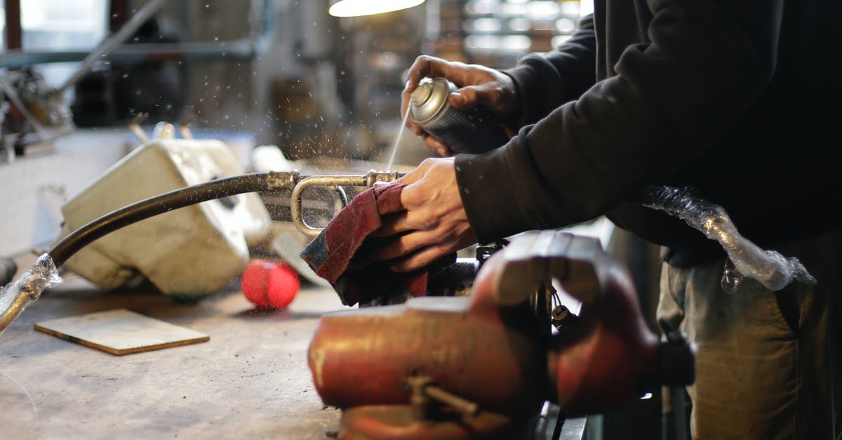 Does an anti scuff spray for luggage exist? - Unrecognizable male mechanic spraying metal detail in workshop