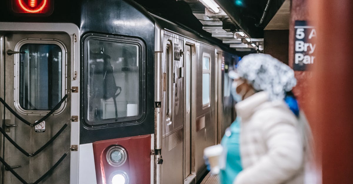 Does any passenger train go between the United States and Mexico via San Ysidro? - Unrecognisable female in medical uniform coat and with paper cup waiting for train arriving on subway platform