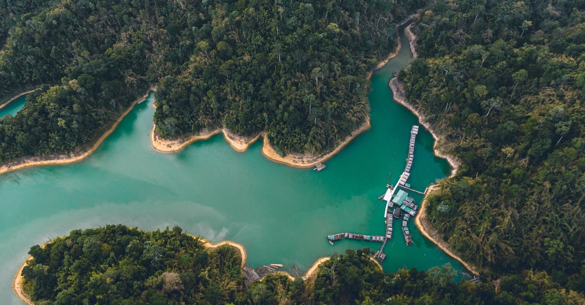 Does anyone know where this beach is located? - Breathtaking drone view of houses on water and sandy coastline surrounded by exotic forest and lagoon