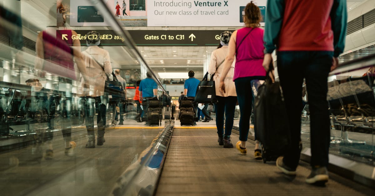 Does DFW have moving walkways in any terminal? - People Using a Moving Walkway in an Airport