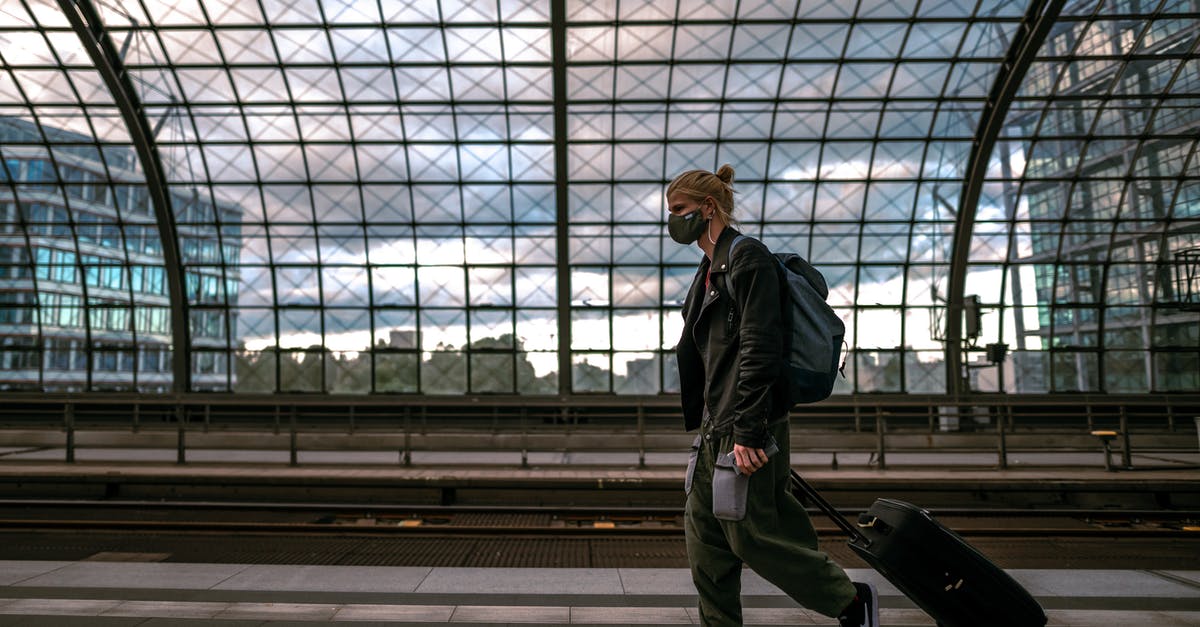 Does every tourist need a sponsor? - Man in Black Jacket and Green Pants Standing on Gray Concrete Floor