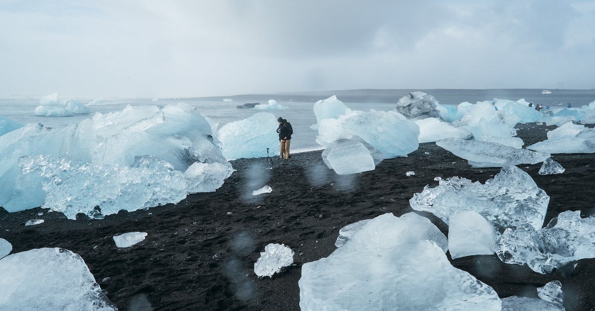 Does it makes sense to travel to Iceland during winter? [closed] - Person Standing Beside Body of Water