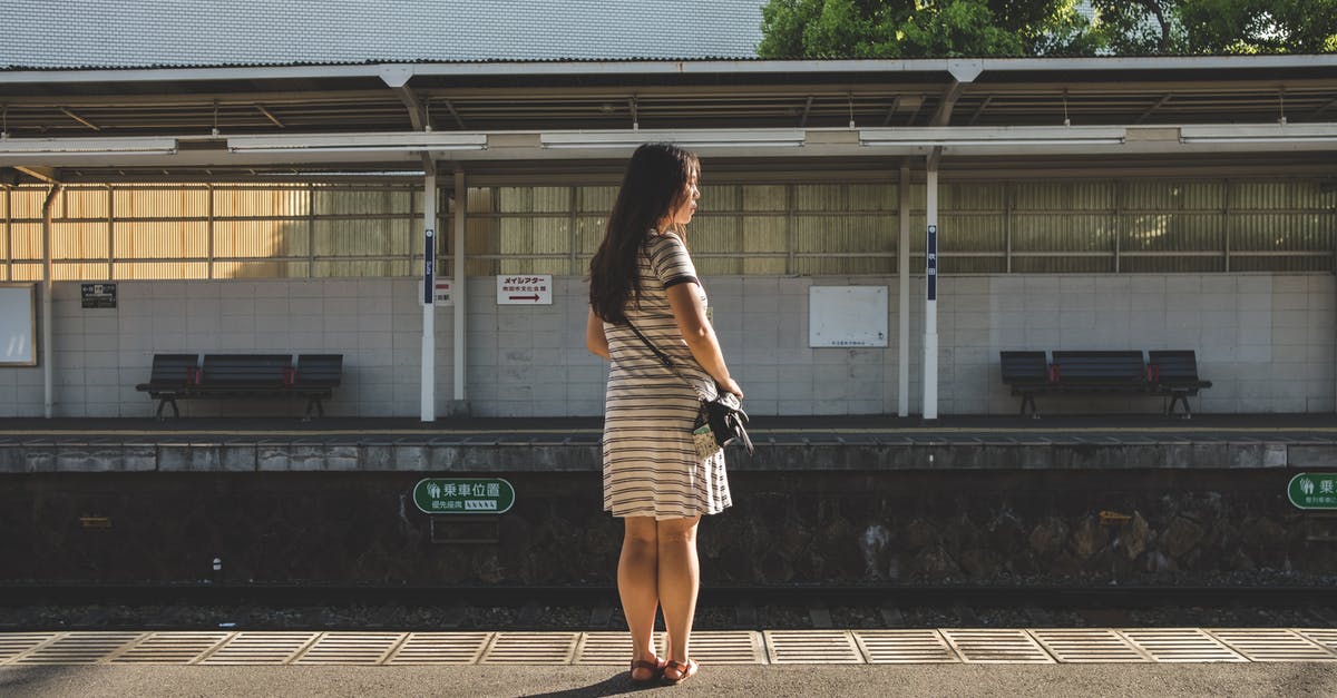 Does Japan Airlines have an unconditional 24-hour refund policy? - Woman in Striped Dress Standing on Railway Platform