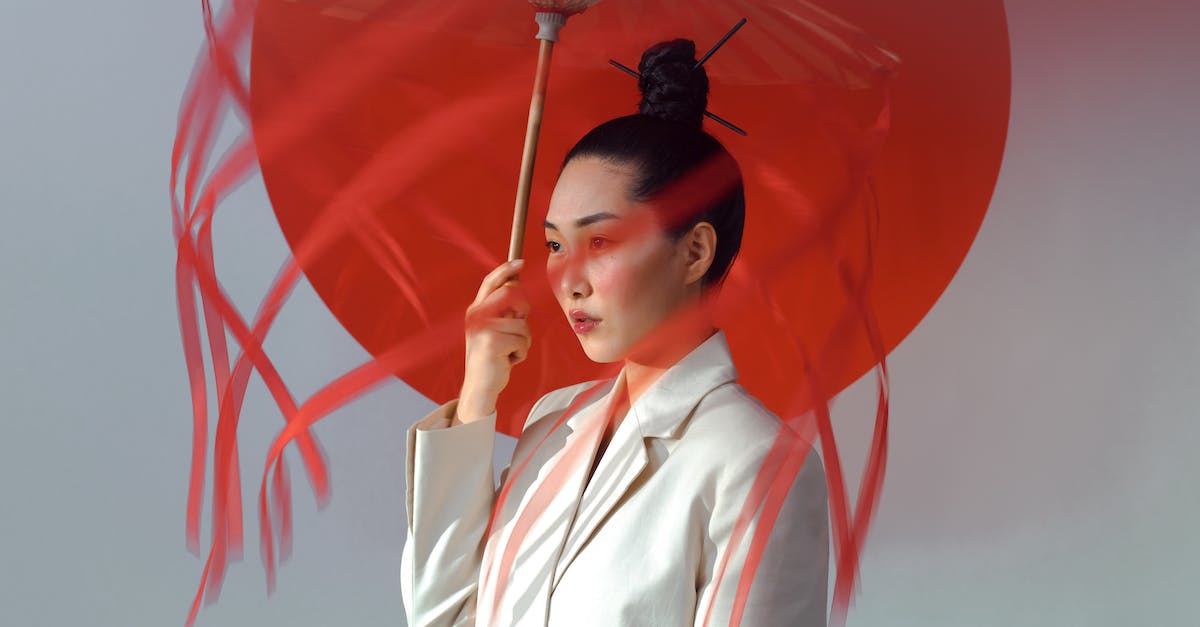 Does knowing Japanese help in neighbouring countries? - Woman in White Blazer Holding Red Umbrella