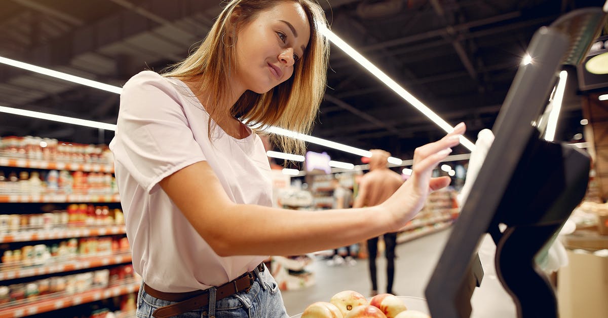 Does LOT strictly control hand luggage weight? - Side view of young woman in trendy clothes weighing peaches on scales while  shopping in supermarket during purchase food