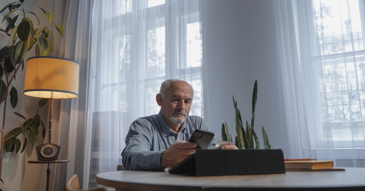 Does MasterCard work in Italy? - A Low Angle Shot of an Elderly Man Using His Mobile Phone