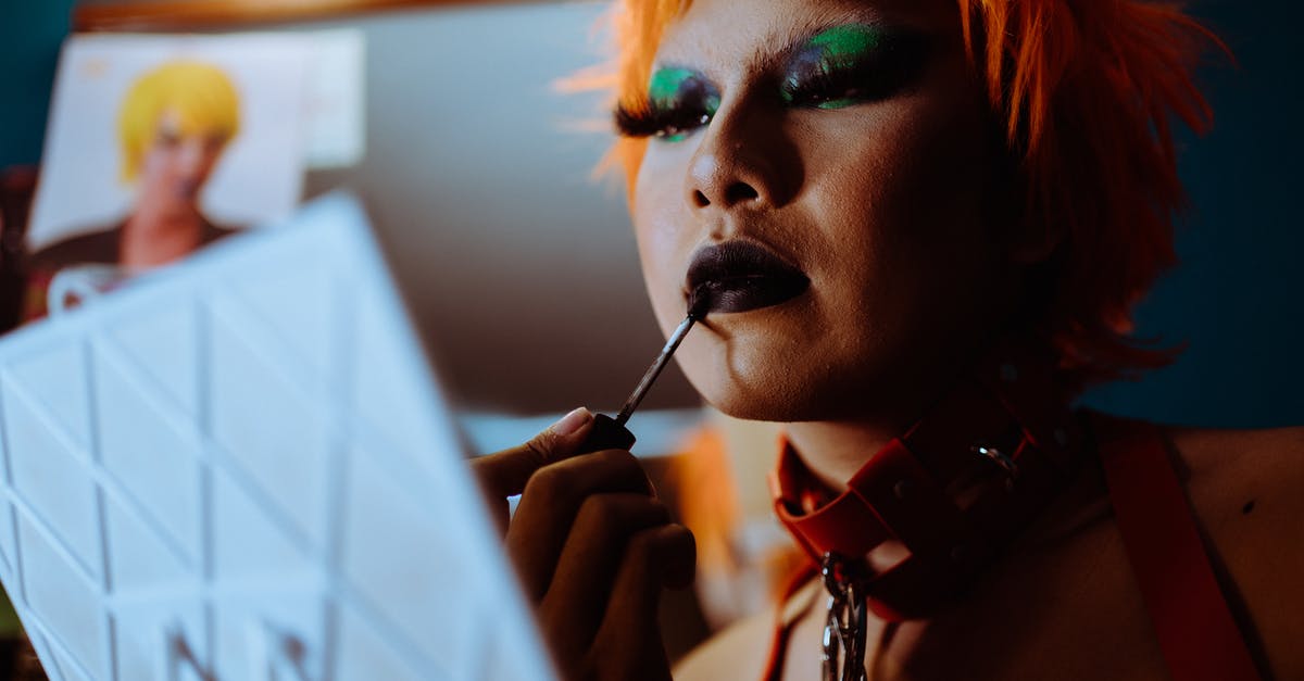 Does Non-Schengen Countries apply to my 90/180 - Low angle of crop ethnic eccentric transgender guy with bright makeup in wig and leather collar applying dark lipstick while preparing for performance in nightclub