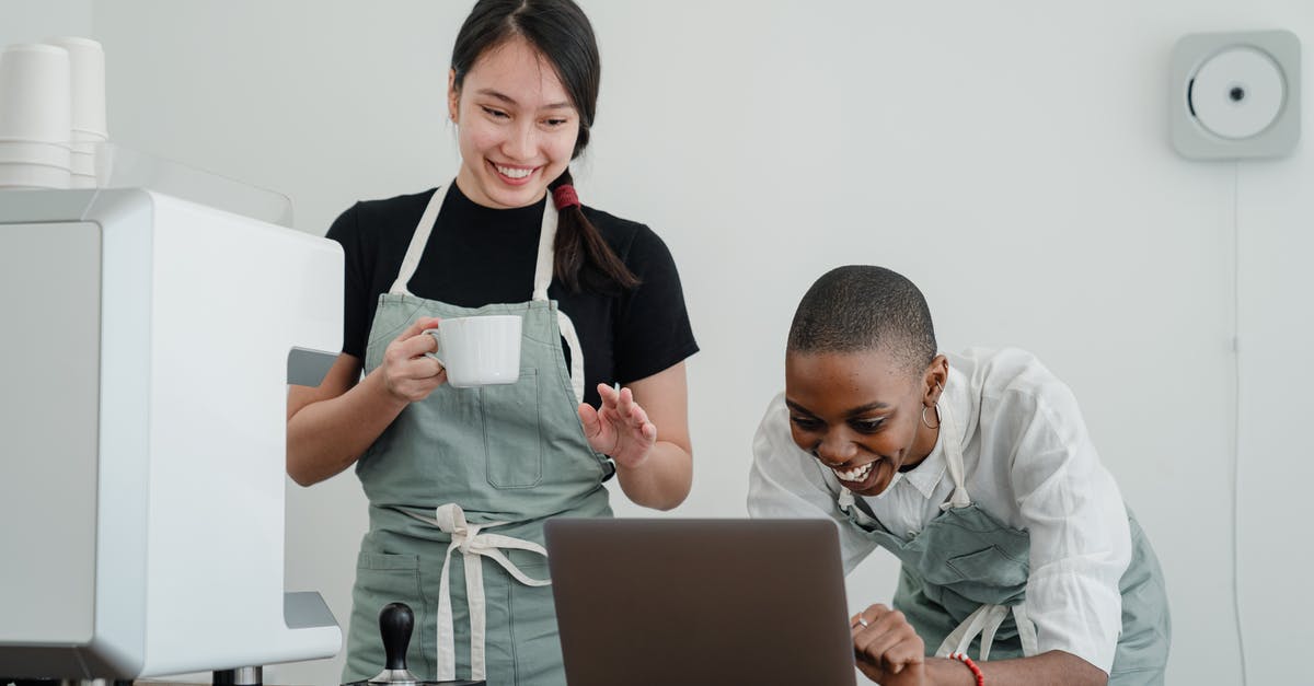 Does StarAlliance's loyality program have a "recommend a friend" program? - Cheerful multiracial female baristas using modern laptop during coffee break