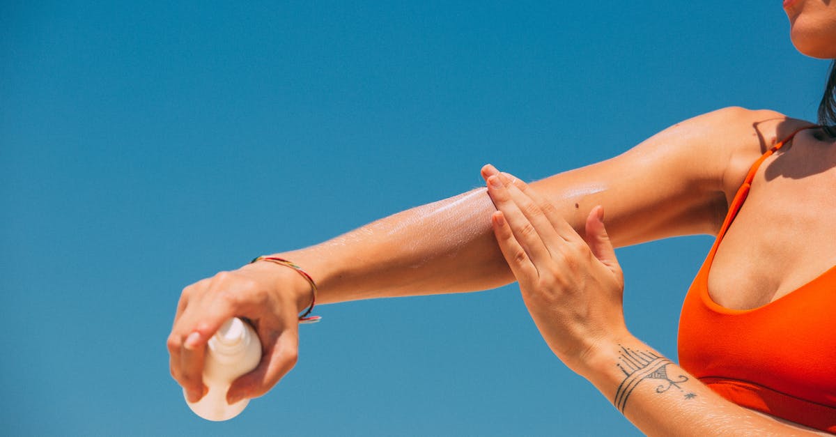 Does sunscreen/suncream stop the amount of skin tan? [closed] - A Woman Applying Sunscreen on Arm