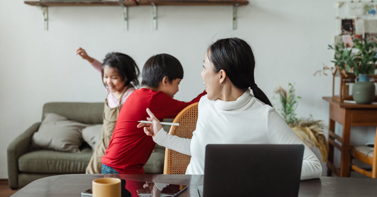 Does the Swiss Family Pass work for siblings? - Young Asian working mother scolding little kids playing and making noise during remote job at home