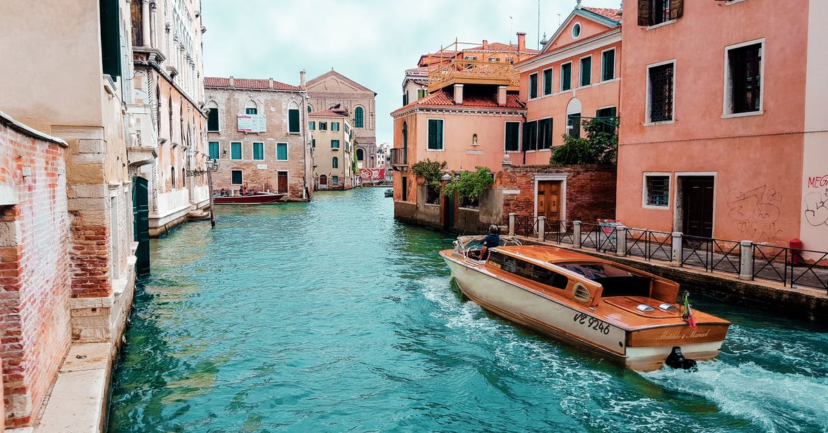 Does Venice smell? - Orange Powerboat Between Medium Rise Buildings