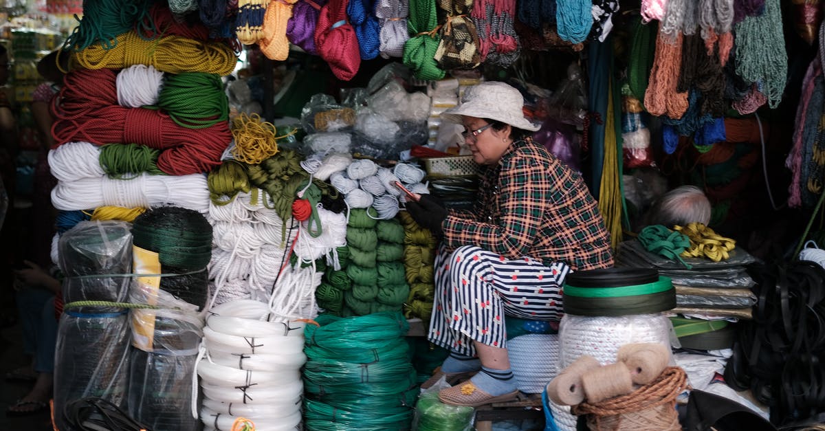 Does Vietnam store visas digitally? - Woman in Black and White Striped Long Sleeve Shirt Sitting In Front Of Her Store