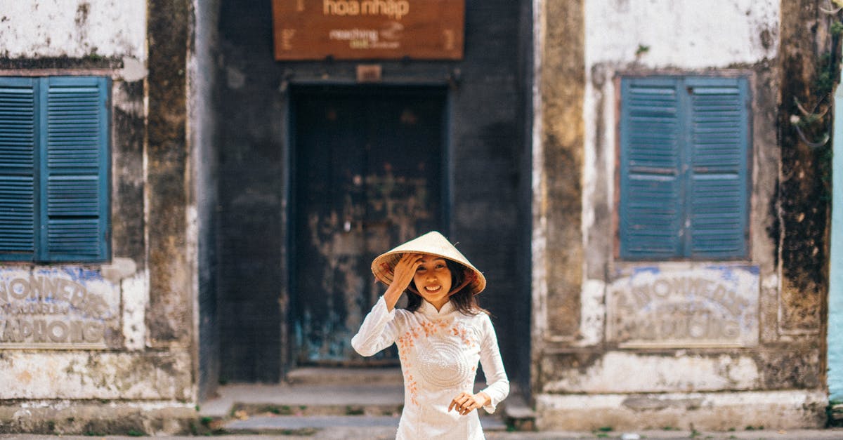 Dos and don'ts at a Vietnamese wedding - Woman Wearing a Conical Hat Standing on a Street