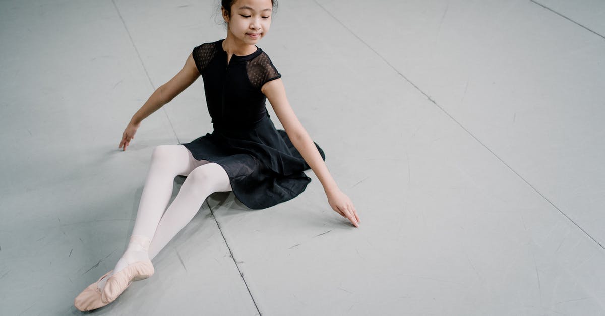 Dress for First Class? - Graceful Asian girl ballerina sitting on floor in studio