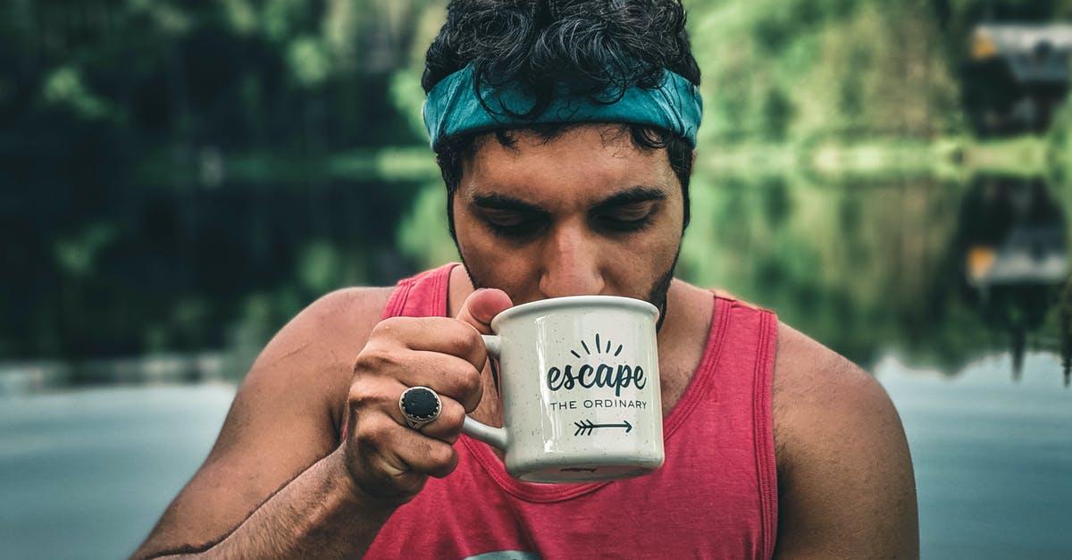 Drinking "wild" coffee in Ethiopia - A Man Pink Tank Top Drinking from a White Ceramic Mug