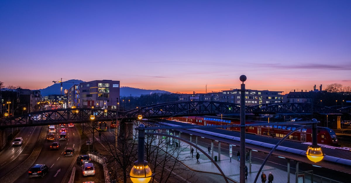 Drive through Germany and Switzerland with barbells as luggage - People Walking on Train Station Near Highway in Distant of Buildings