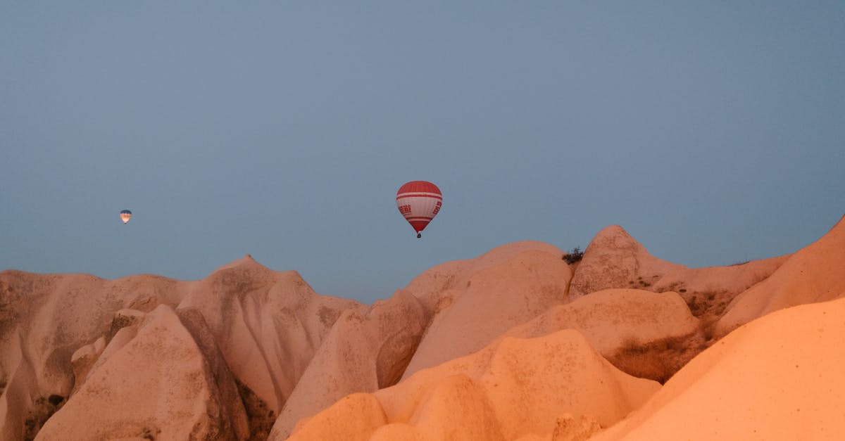 Drive to Chimney Rock - Picturesque view of hot air balloons flying over rocky chimneys with smooth surface in Cappadocia on early morning