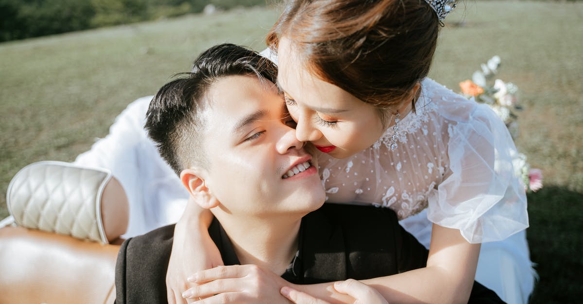 Driving from Denver to DC in December [closed] - Happy Asian bride in white wedding dress and diadem sitting on back seat of retro car and embracing handsome young groom after wedding ceremony