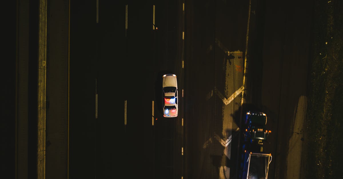 Driving from Melbourne to Sydney on the Hume Highway, where should we stop for the night? - From above of police cruiser with flashing lights driving on asphalt road along dimly illuminated street at night