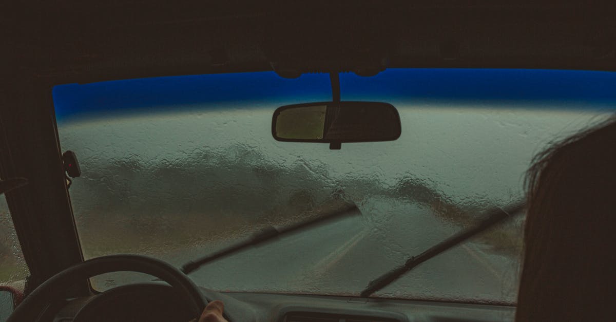 Driving into Germany over Easter weekend - Crop unrecognizable travelers sitting in automobile with wet windshield and wipers in rainy weather