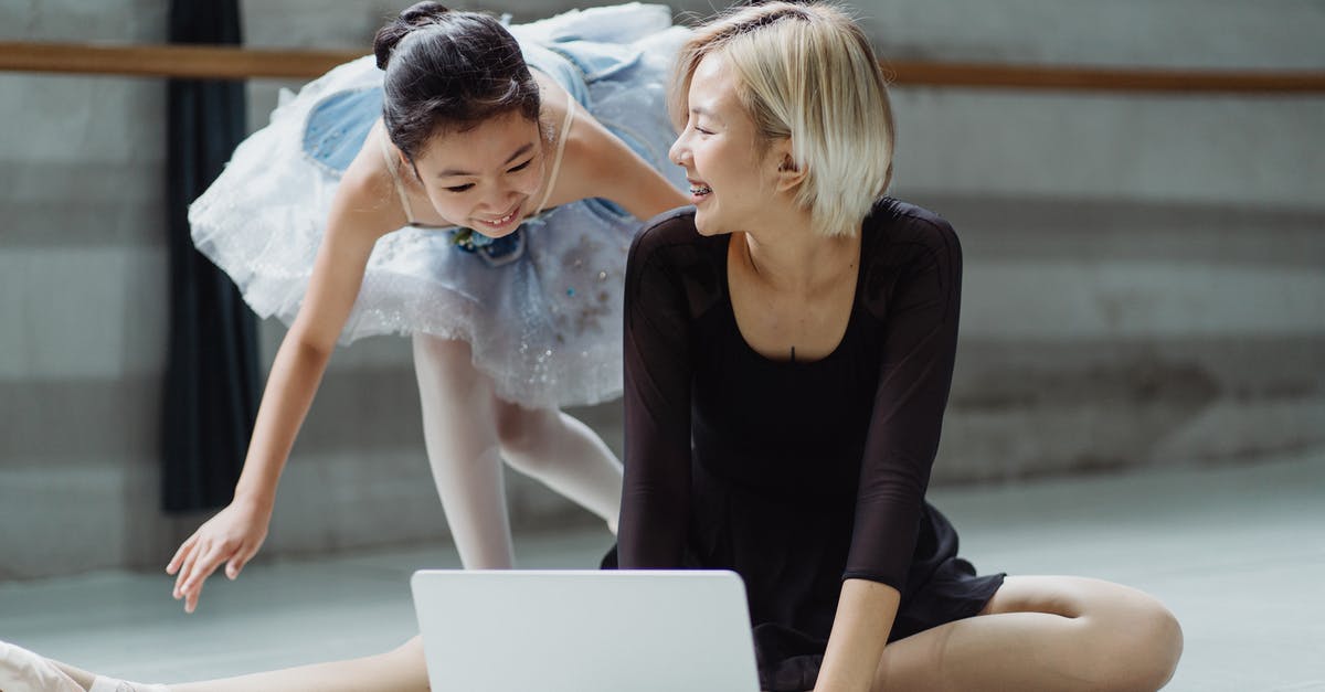 Drones in Barbados - importation banned, but personal use? - Cheerful Asian ballerina in tutu skirt with personal trainer searching information in netbook while laughing together in ballet studio