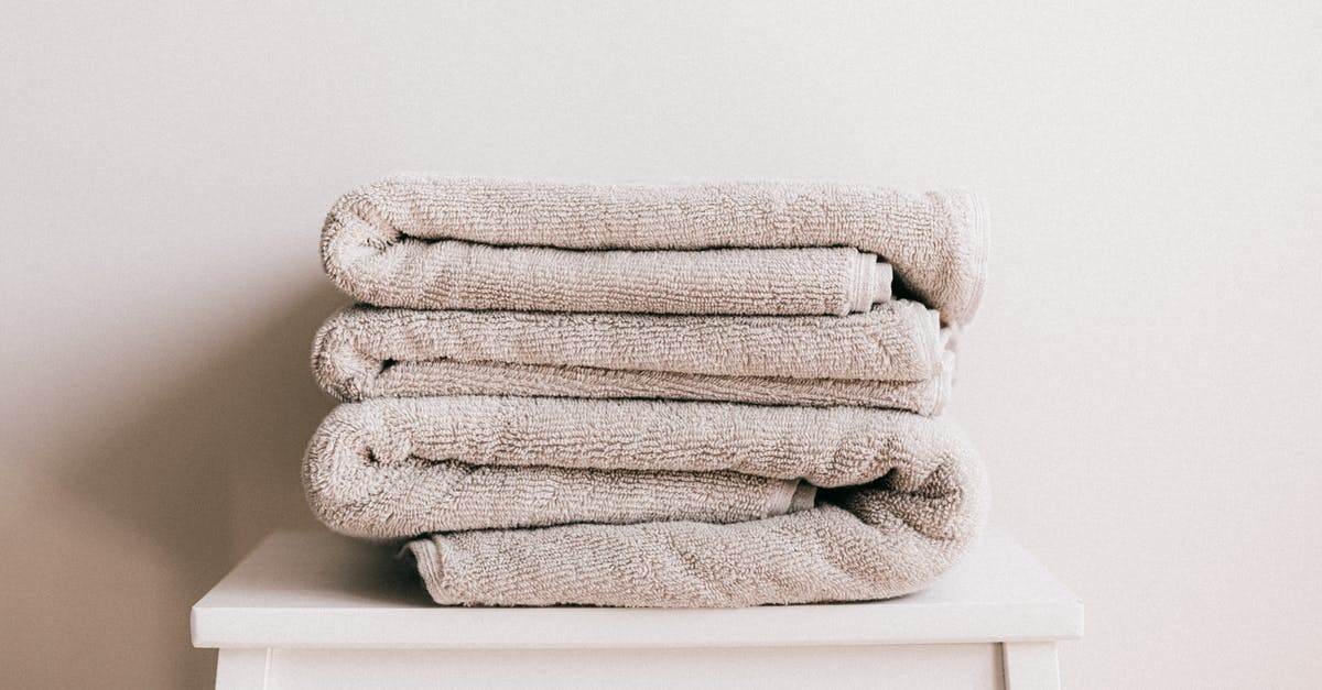 Dry ice in various EU countries? - Stack of soft clean light beige folded towels placed on white minimalist stool against beige wall in daylight