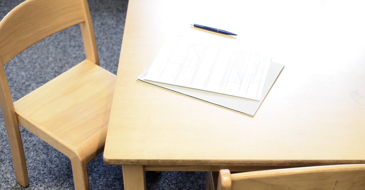 DS 160 form for non-immigrant visa application - From above of application form on paper sheets near pen on wooden desk in daylight