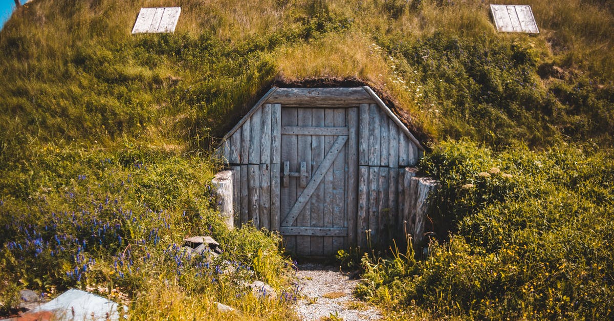 Dual Citizen (US-Iranian) seeking travel to Canada. Visited Iran 2011 - Old typical sod roofed house with wooden doors located in Norstead Viking Village in Newfoundland on sunny day