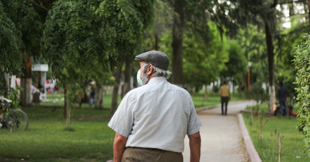 Dual citizen US/Ireland need healthcare in EU [closed] - Unrecognizable citizen in medical mask walking on pavement in park