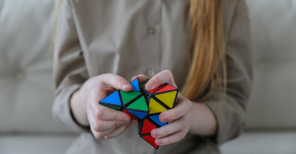 Dual citizenship, question about which one can I use [duplicate] - Crop anonymous girl demonstrating and solving colorful puzzle with triangles in soft focus