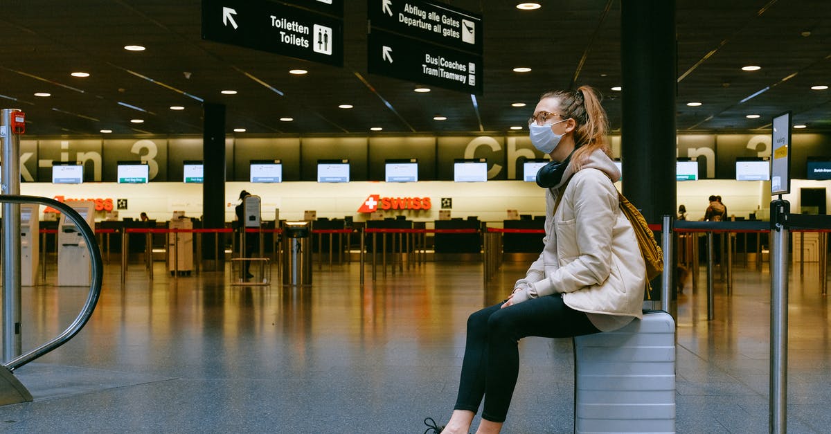 Dubai Airport changing terminals - Woman Sitting on Luggage