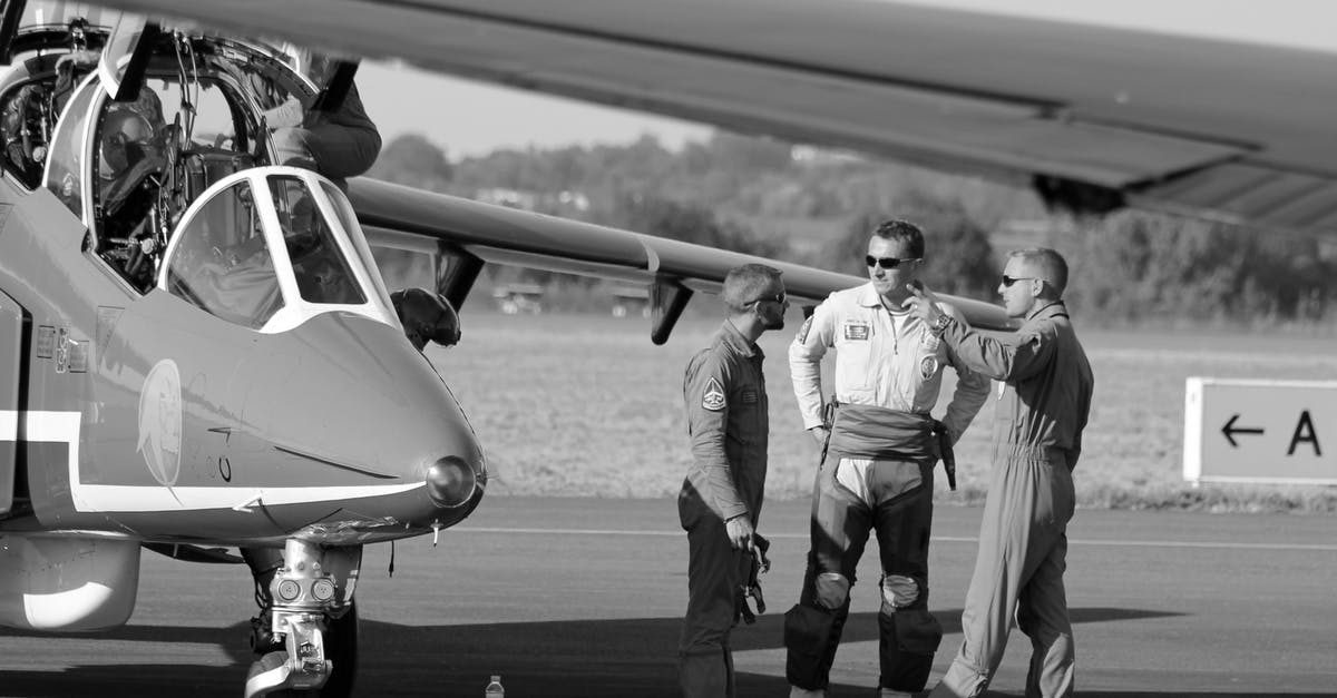 Dubai airport enquiries - Grayscale Photo of 2 Men Standing Near Airplane