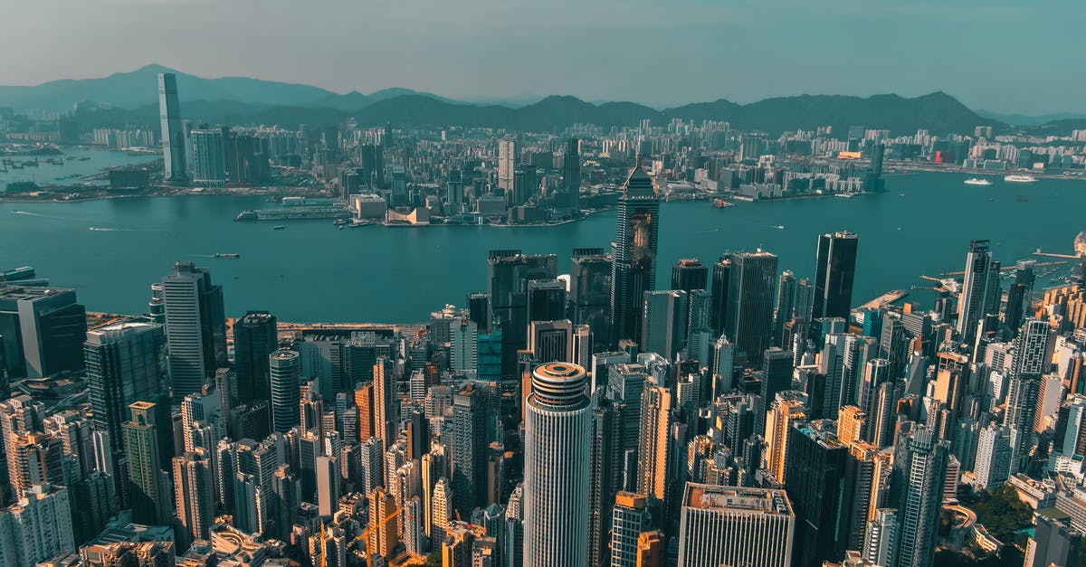 Duty free liquor from Hong Kong to China - From above of contemporary skyscrapers of modern megapolis located on shore of river against blue sky