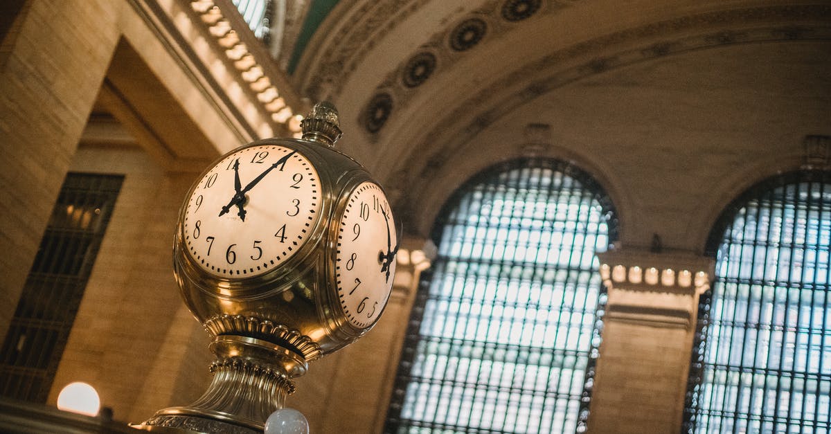 Duty-free shopping after 48 hours from US to Canada - From below of vintage golden clock placed in hallway with aged interior with ornamental walls and windows and high ceilings placed in Grand Central Terminal in New Your City in daytime