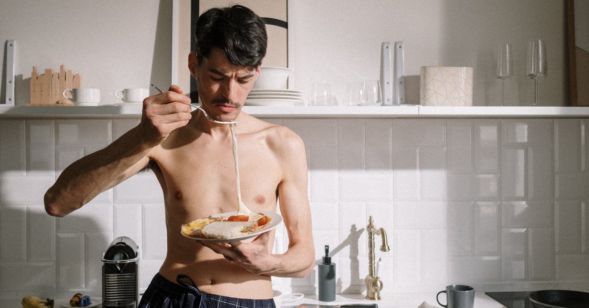 Early breakfast availability in Japan? - Man in Blue Shorts Holding Brown Ceramic Bowl