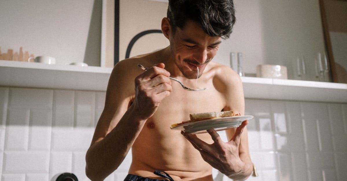 Early breakfast availability in Japan? - Topless Man in Blue Denim Shorts Holding White Ceramic Plate