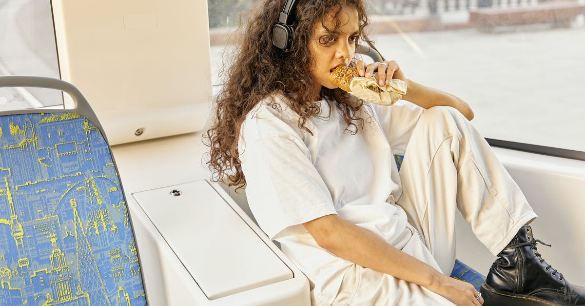 Eating alone in London - A Girl Eating Bread while Listening on Her Headphones