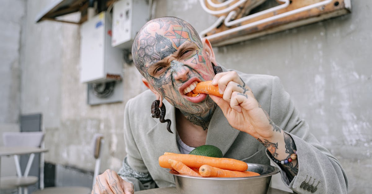 Eating in Masuria/Mazury - a good destination for vegetarians? - Person in Gray Long Sleeve Shirt Holding Brown and White Ceramic Bowl With Sliced Orange Fruit