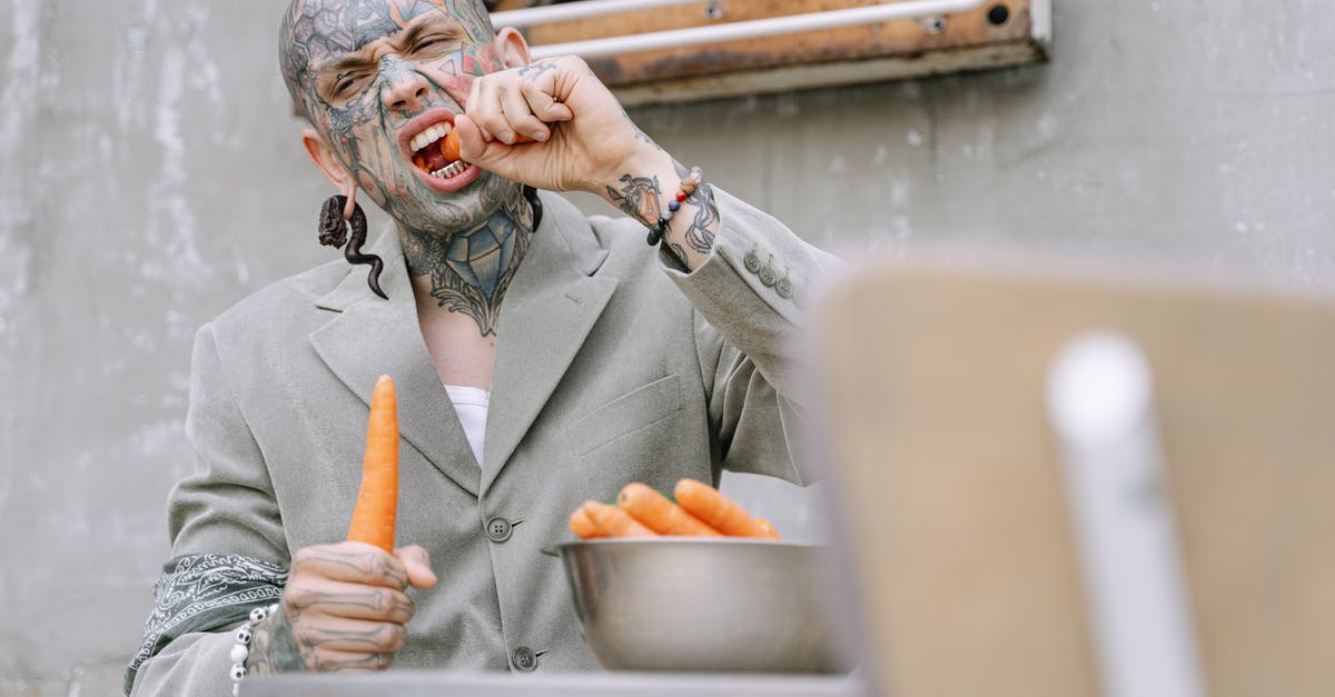 Eating in Masuria/Mazury - a good destination for vegetarians? - Woman in Gray Coat Holding Orange Fruit